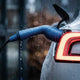 Weatherproof EV charging connector plugged into a car with rain drops on the bodywork